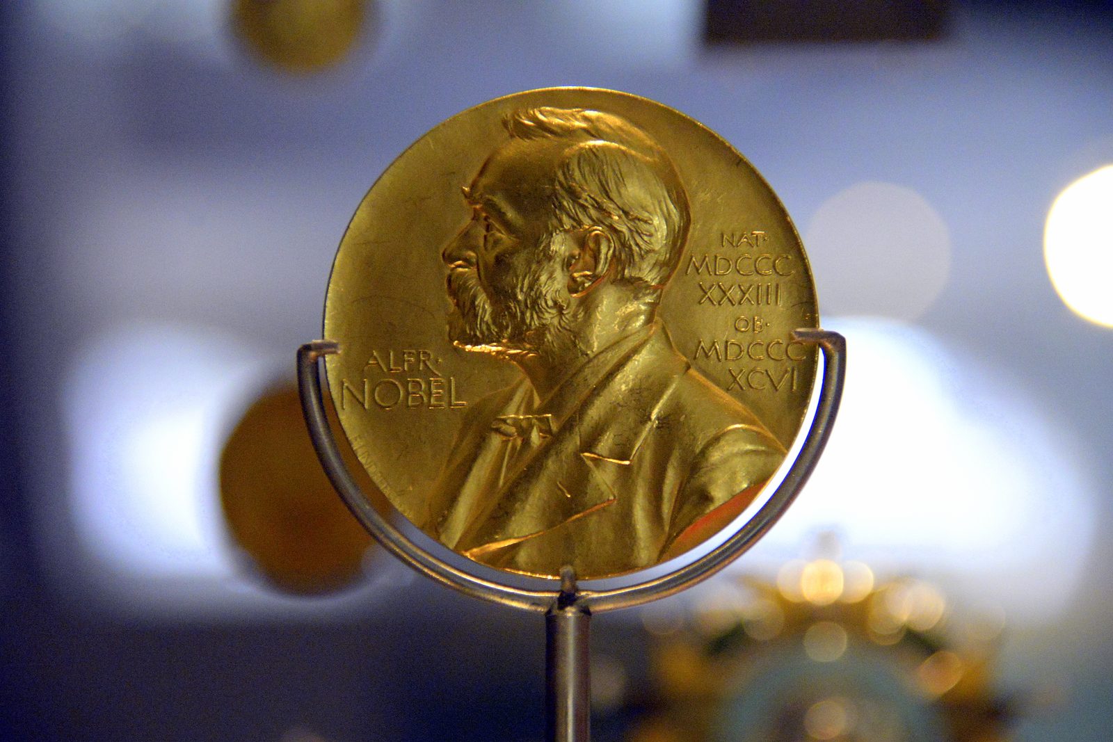 Both faces of a gold Nobel Prize medal: Alfred Nobel in profile on the front, and on the reverse the allegorical figures of Nature and the Genius of Science.